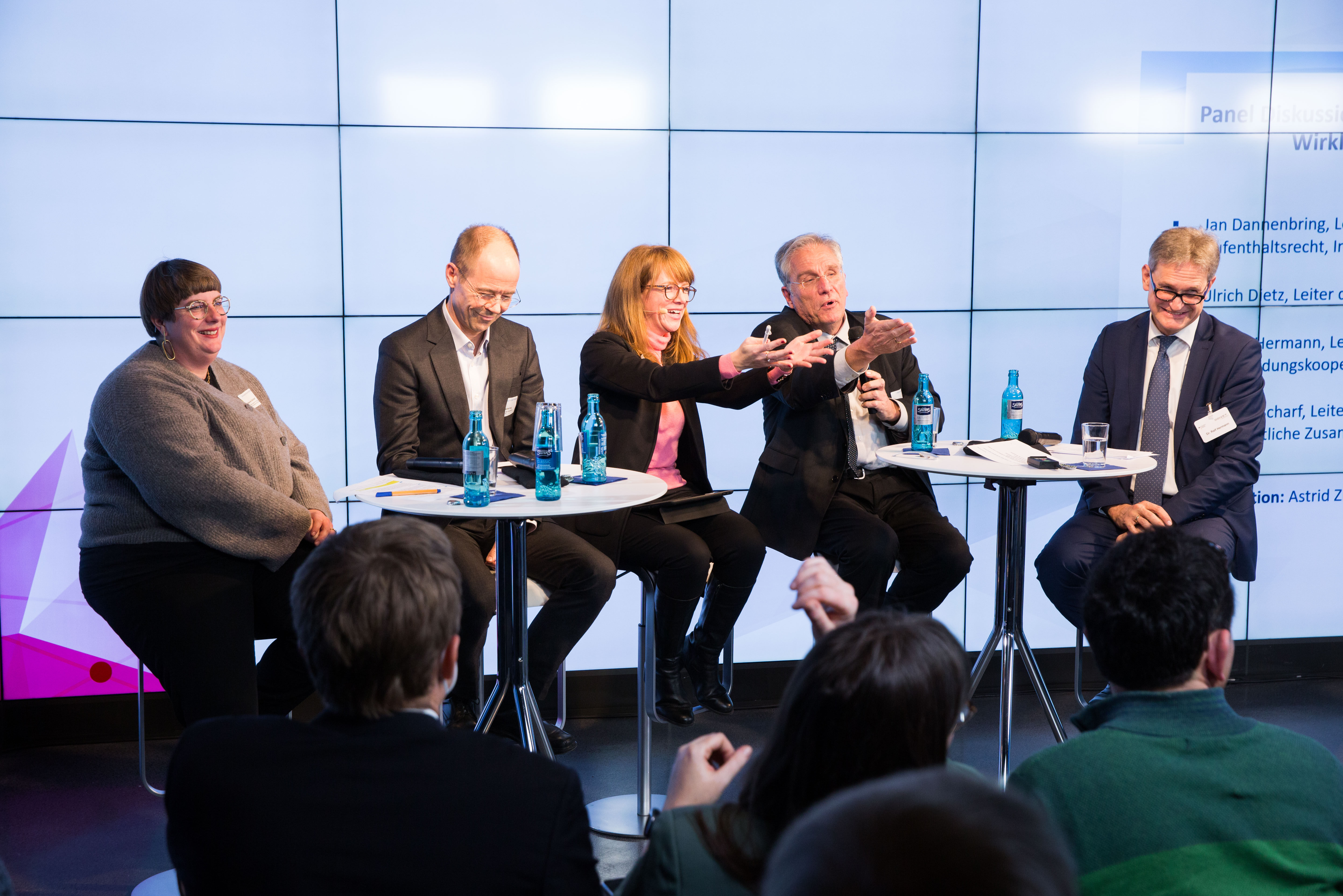 die 5 Panelisten sitzen auf dem Podium und diskutieren