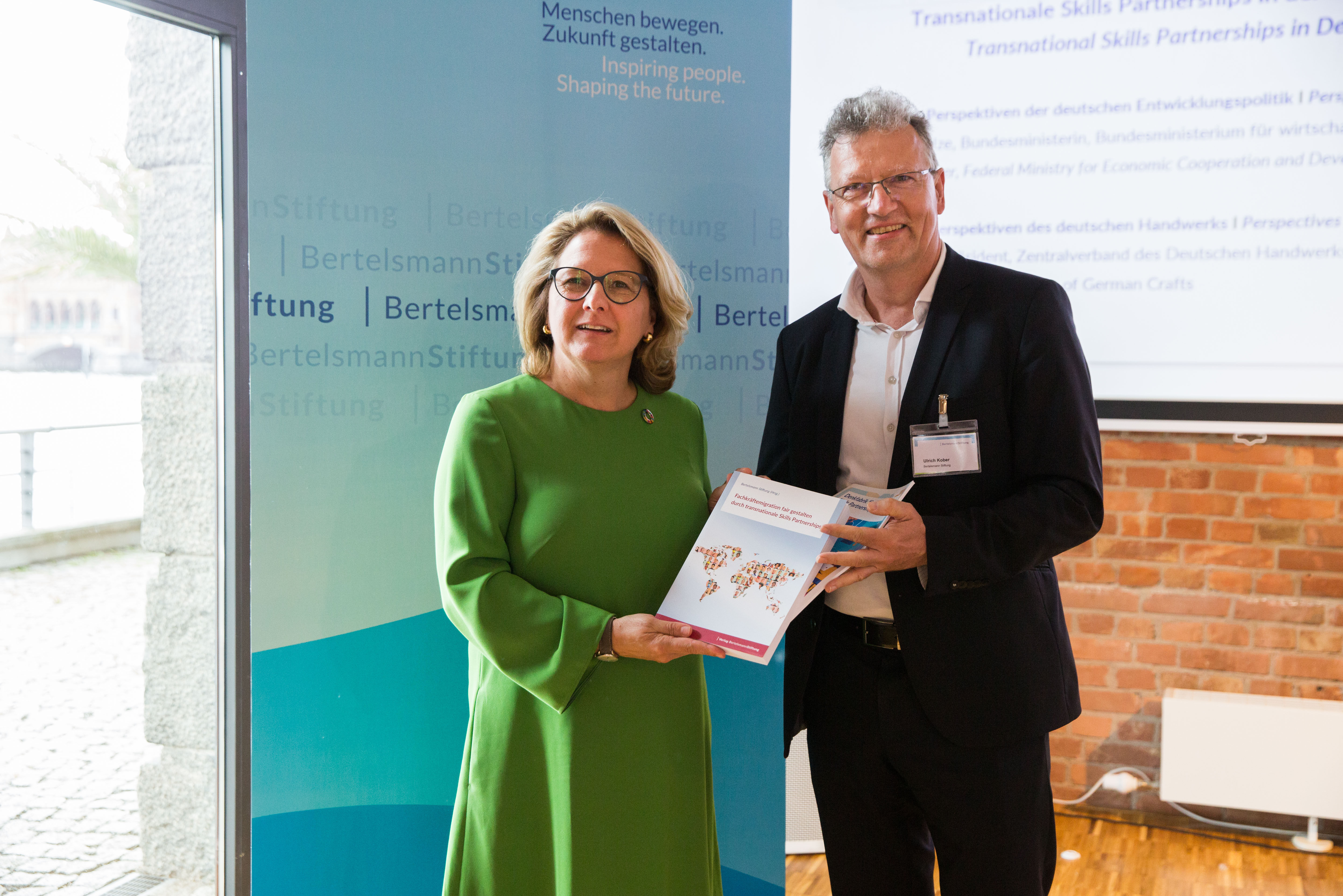 Ulrich Kober von der Bertelsmann Stiftung übergibt die Abschlusspublikation „Fachkräftemigration fair gestalten durch transnationale Skills Partnerships“ an die Bundesministerin für wirtschaftliche Zusammenarbeit und Entwicklung Svenja Schulze